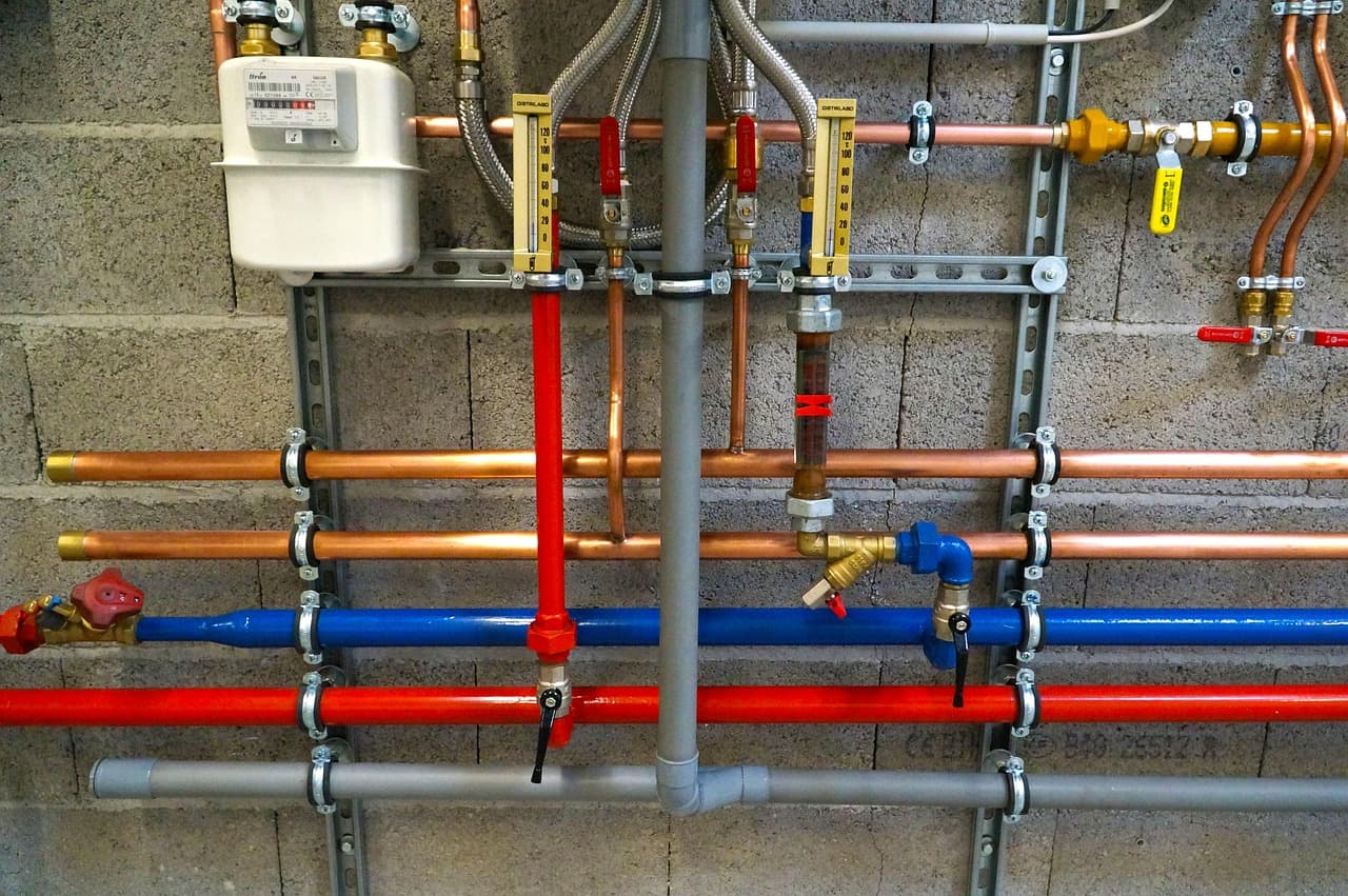 Copper, red and blue water pipes on a wall